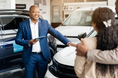 Araç satın alıyorum. Profesyonel Oto Satış Merkezi 'nde Afrikalı Aile Araba Danışmanlığı yapıyor. Seçici Odaklanma. Yüksek kalite fotoğraf