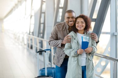 Seyahat Konsepti. Pasaportları ve havaalanı terminalinde biletleri olan Afrikalı çift pozu, tatil gezisi, kapanış. Yüksek kalite fotoğraf