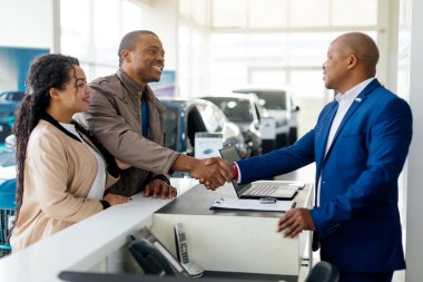 Genç Afrikalı Amerikalı çift bir galeride araba satın alma sürecine giriyorlar. Anlaşmayı sonuçlandırırken satış müdürüyle el sıkışıyorlar..
