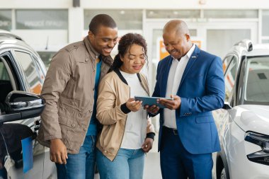 Genç bir Afro-Amerikalı çift, galeri müdürüyle birlikte araç seçeneklerini değerlendiriyor ve galeride araba satın alma hevesini sergiliyorlar. Nişanlandılar ve planlarını tartışıyorlar..