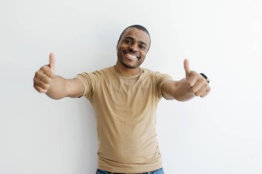 Neşeli Siyah Adam Kamerada İki Elle Başparmaklarını Gösteriyor, Beyaz Stüdyo Arkaplanının Üzerinde Dururken, Heyecanlı Afrikalı Amerikalı Erkek Erkek İşaret İşareti, Uzayı Kopyala