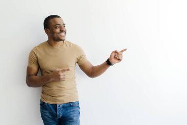 Şuna bak. İki eliyle fotokopi uzayını gösteren mutlu siyah erkek, beyaz arka planda dururken boş bir reklam yeri gösteren neşeli Afrikalı Amerikalı.