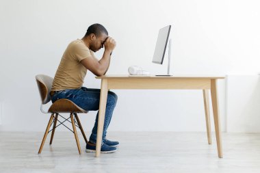 Stresli Afro-Amerikan bir adamın portresi ahşap masada oturuyordu. Kafası ellerindeydi. Siyahi bir adam derin düşüncelere dalmıştı.