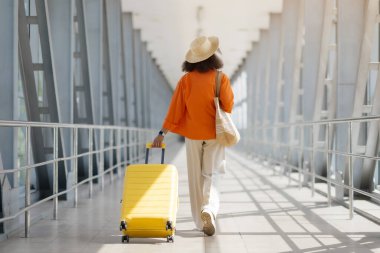 Hava Yolları Konsepti. Hasır Şapkalı Bayan Gezgin 'in Havalimanında Yürüyüşü, Bavulu Terminaldeki Kapıya Giden Tanımlanamayan Genç Kadın, Yolculuğa Hazır, Boşluğu Kopyala