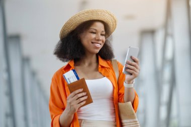 Uçuşu bekliyorum. Havalimanı Terminalinde Akıllı Telefon Kullanan Genç Siyah Kadın, Cep Telefonu 'nda Afro-Amerikan Kadın Tarayıcısı Ya da Uçağa Binmeden Önce Online Otel Rezervasyon, Kapanış