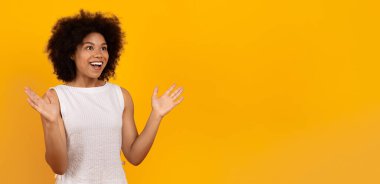 Büyük sürpriz. Coşkulu siyahi kadın elini kaldırıyor ve heyecanla bağırıyor, mutlu Afrikalı Amerikalı kadın iyi habere duygusal tepki veriyor ya da teklif ediyor, sarı arka planda izole edilmiş.