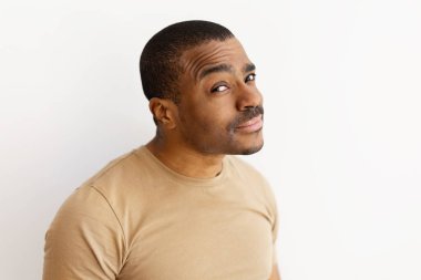 Siyahi adam şüpheci ya da şüpheli bir ifadeyle kaşlarını kaldırıyor. Kuşkuyu, şüpheyi ya da merakı simgeleyen sıradan bir jest. İnce alaycılıkla, taklit alanı.