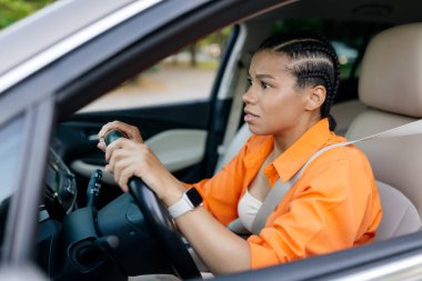 Endişeli genç Afrikalı Amerikalı kadın gergin bir ifadeyle araba kullanıyor. Trafikte veya beklenmedik bir durumda muhtemelen gergin ya da endişeli, yakın çekim