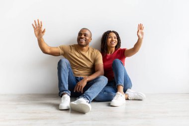 Gülümseyen Afro-Amerikan çift evlerinde oturmuş, görünmez nesnelere neşeli ifadelerle dokunuyorlar, bağlantıyı, dostluğu ve modern yaşam tarzını temsil ediyorlar, kopyalama alanını.