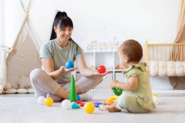 Anne ve bebek evde renkli oyuncaklarla oynuyorlar. Aile sevincinin yaşam tarzı, annelik bağı, öğrenme, bakım ve erken çocukluk eğlencesi