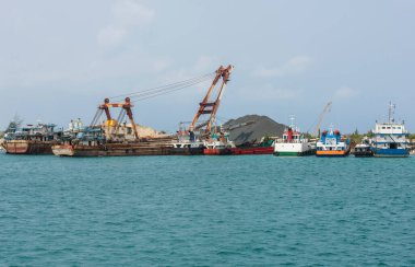 Tropikal lagündeki ticari sanayi nakliye limanına demirlemiş küçük kargo gemileri.