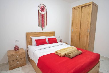 Interior design decor furnishing of luxury show home bedroom showing furniture and double bed in resort with wooden wardrobe