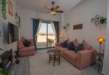 Living room lounge area in luxury tropical apartment show home showing interior design decor furnishing with balcony terrace