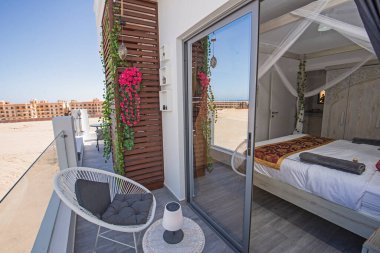 Terrace furniture of a luxury apartment in tropical resort with table and chairs on balcony by bedroom