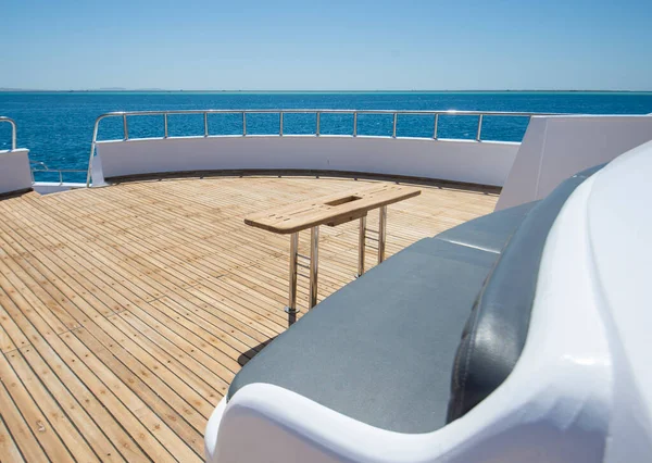 椅子ソファテーブルと熱帯の海の景色の背景を持つ大規模な高級モーターヨットのチーク弓デッキ — ストック写真