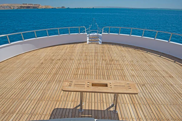 木制桌子和热带海景背景大型豪华游艇的精致船头甲板 — 图库照片