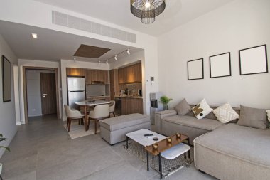 Lüks tropikal tatil dairesindeki oturma odası salonu açık mutfak tasarımlarıyla döşenmiş iç tasarım dekorasyonunu gösteriyor.