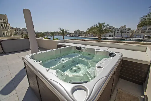 Roof terrace patio furniture at a luxury holiday villa in tropical resort with hot tub and marina view