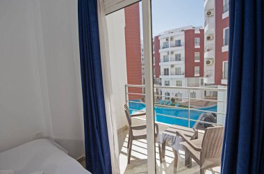 Lüks mobilyaların iç dizayn dekorasyonu ev yatak odasını gösteriyor ve çift kişilik yatak ve balkon.