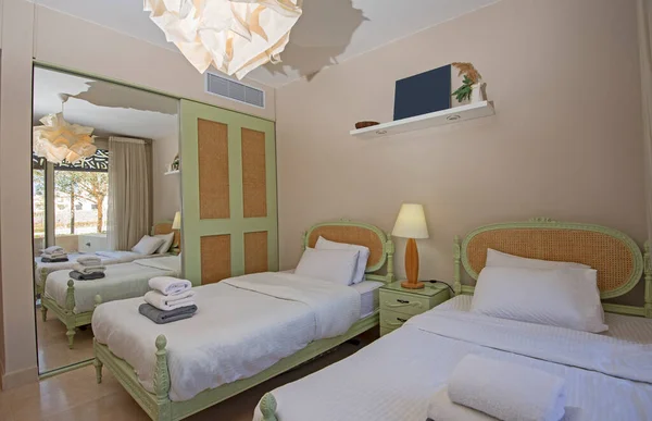 옷장을 그리고 쌍둥이 침대를 보여주는 호화스러운 침실의 디자인 스톡 사진