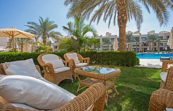 Gartenterrassenmöbel Einer Luxuswohnung Tropischen Resort Mit Möbeln Und Poolblick lizenzfreie Stockfotos
