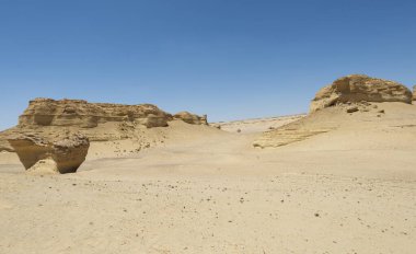 Landscape scenic view of desolate barren western desert in Egypt with geological mountain sandstone rock formations clipart