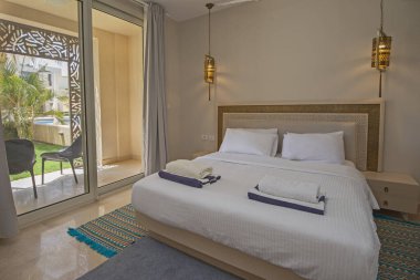 Lüks mobilyaların iç dizayn dekorasyonu ev yatak odasını gösteriyor ve bahçe manzaralı çift kişilik yatak.