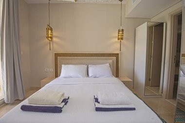 Lüks mobilyaların iç dizayn dekorasyonu ev odası mobilyaları ve asılı ışıklarla çift kişilik yatakları gösteriyor.