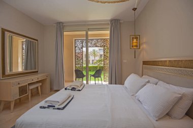 Lüks mobilyaların iç dizayn dekorasyonu ev yatak odasını gösteriyor ve bahçe manzaralı çift kişilik yatak.