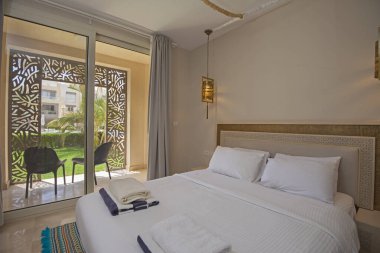 Lüks mobilyaların iç dizayn dekorasyonu ev yatak odasını gösteriyor ve bahçe manzaralı çift kişilik yatak.