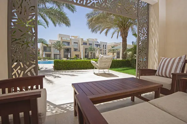 热带旅游胜地豪华公寓的花园露台 有家具和游泳池 图库图片