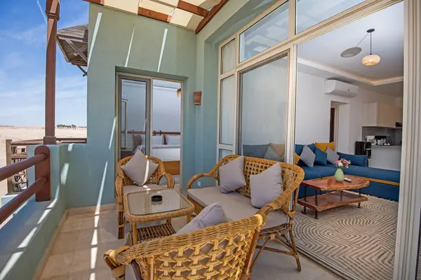 热带旅游胜地豪华公寓的露台家具 从阳台上可以看到家具和海景 图库照片