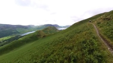 Uzak bir dağ tepesi patikası boyunca kırsal alanda çarpıcı manzaralı patika boyunca yürüyen ilk kişi görüntüsü.