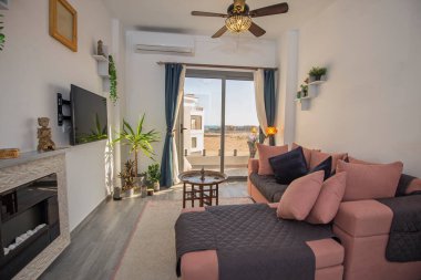 Lüks apartmandaki oturma odası salonu teras balkonuyla döşenmiş iç dizayn dekorasyonunu gösteriyor.