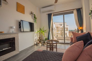 Lüks apartmandaki oturma odası salonu teras balkonuyla döşenmiş iç dizayn dekorasyonunu gösteriyor.