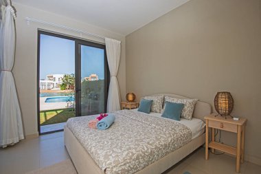 Lüks mobilyaların iç dizayn dekorasyonu ev yatak odasını gösteriyor ve bahçe manzaralı çift kişilik yatak.