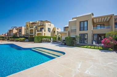 Bahçesi olan lüks bir tropikal apartman dairesinde geniş bir açık havuz manzarası.