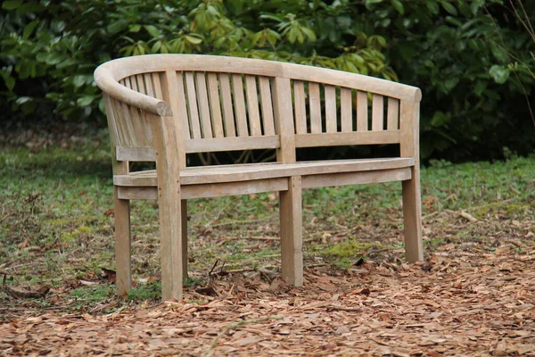 一个长曲的木制公园长椅座位 — 图库照片