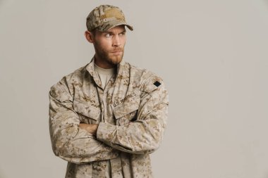 Üniformalı beyaz bir asker beyaz arka planda izole edilmiş bir şekilde poz veriyor.