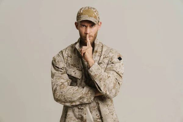 White military man wearing uniform making silence gesture isolated over white background
