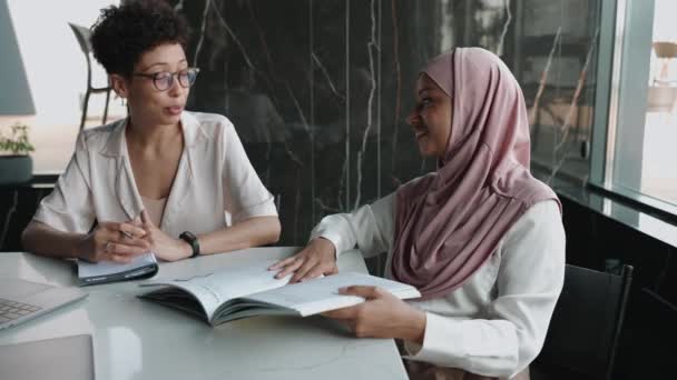 两名积极的多族裔穆斯林妇女和非洲妇女在办公室里交谈 — 图库视频影像