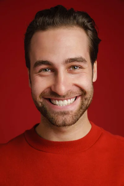 Młody Włosiany Mężczyzna Swetrze Uśmiechnięty Patrzący Kamerę Odizolowany Czerwonym Tle — Zdjęcie stockowe