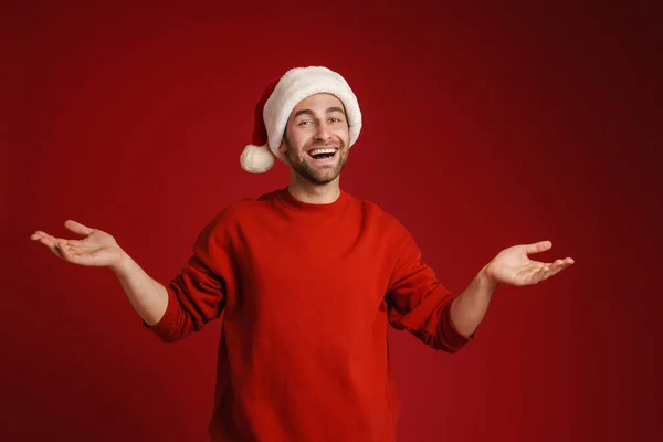 Young Smiling Man Wearing Santa Hat Holding Copyspace Isolated Red — Stock Photo, Image
