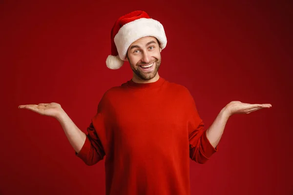 Jovem Sorrindo Homem Vestindo Chapéu Santa Segurando Copyspace Isolado Sobre — Fotografia de Stock