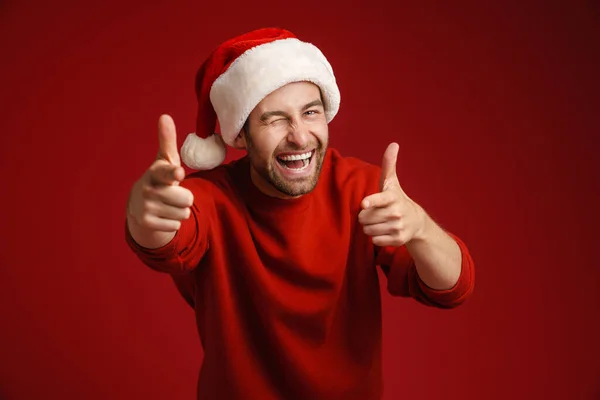 Mladý Štětinatý Muž Sobě Vánoční Klobouk Ukazuje Prsty Kameru Izolované — Stock fotografie