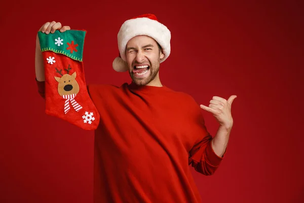 Ung Man Bär Santa Hatt Poserar Med Jul Strumpa Isolerad — Stockfoto