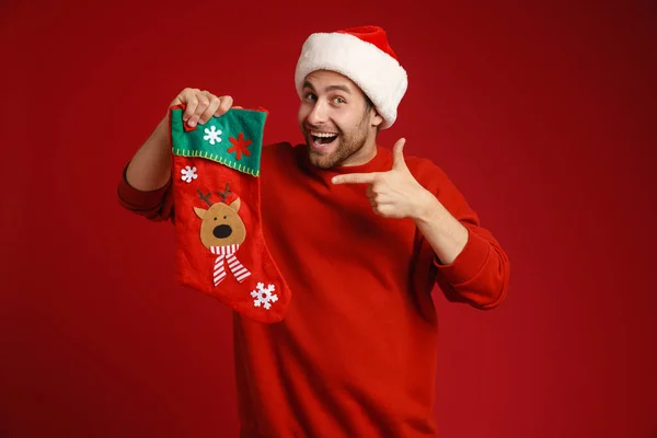 Young Man Wearing Santa Hat Posing Pointing Finger Christmas Sock — Stock Photo, Image