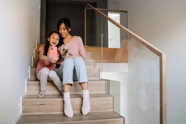 Asian Mother Daughter Taking Selfie While Sitting Dog Stairs Home — Fotografia de Stock