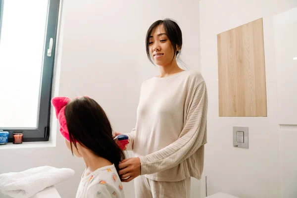 Asian Mother Combing Her Daughter Hair Bathroom Home — Fotografia de Stock