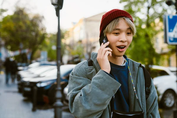 거리에서 휴대폰으로 통화하는 아시아 소년이 표정을 — 스톡 사진